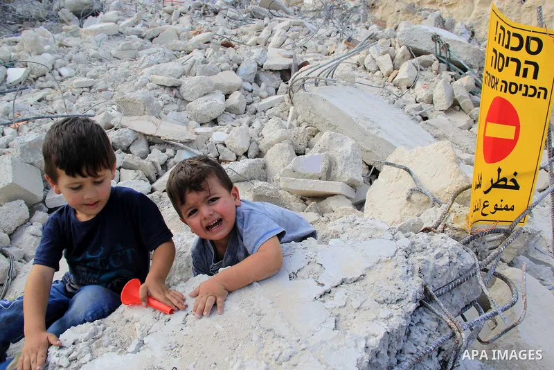 Palestinian children walk on the rubbles of their family house that was demolished after Israeli authorities said it was built without a permit in Wadi Qaddum in the East Jerusalem neighborhood of Silwan on Oct. 26, 2016...