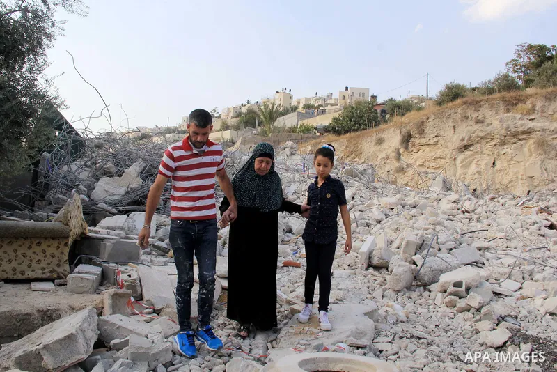 Palestinians walk on the rubbles of their family house that was demolished after Israeli authorities said it was built without a permit in Wadi Qaddum in the East Jerusalem neighborhood of Silwan on Oct. 26, 2016. A mult...