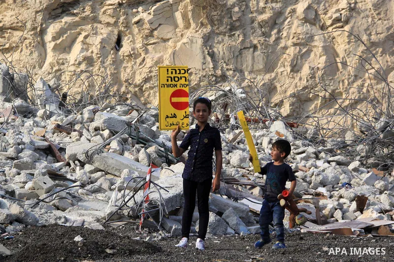 Palestinian children walk on the rubbles of their family house that was demolished after Israeli authorities said it was built without a permit in Wadi Qaddum in the East Jerusalem neighborhood of Silwan on Oct. 26, 2016...