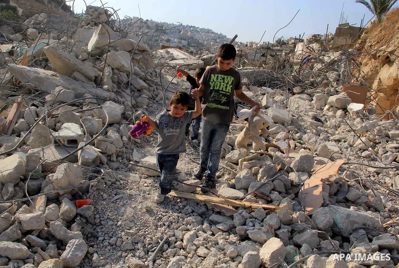 Palestinian children walk on the rubbles of their family house that was demolished after Israeli authorities said it was built without a permit in Wadi Qaddum in the East Jerusalem neighborhood of Silwan on Oct. 26, 2016...