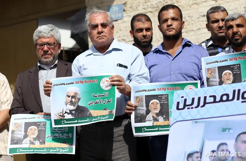 Palestinian members of Hamas legislative council and members of the factions hold banners during a protest to show solidarity with Leader of the northern Islamic Movement Sheikh Raed Salah who is in solitary confinement...