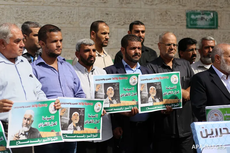 Palestinian members of Hamas legislative council and members of the factions hold banners during a protest to show solidarity with Leader of the northern Islamic Movement Sheikh Raed Salah who is in solitary confinement...