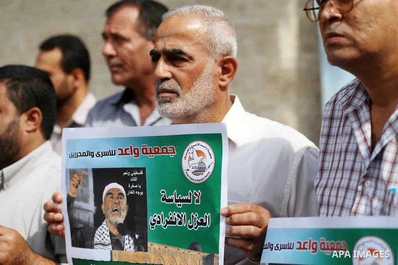 Palestinian members of Hamas legislative council and members of the factions hold banners during a protest to show solidarity with Leader of the northern Islamic Movement Sheikh Raed Salah who is in solitary confinement...