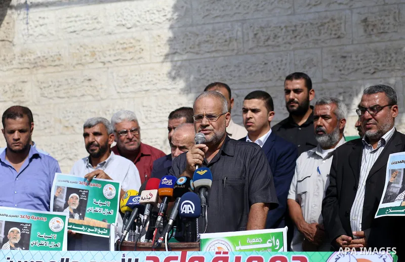 Palestinian members of Hamas legislative council and members of the factions hold banners during a protest to show solidarity with Leader of the northern Islamic Movement Sheikh Raed Salah who is in solitary confinement...