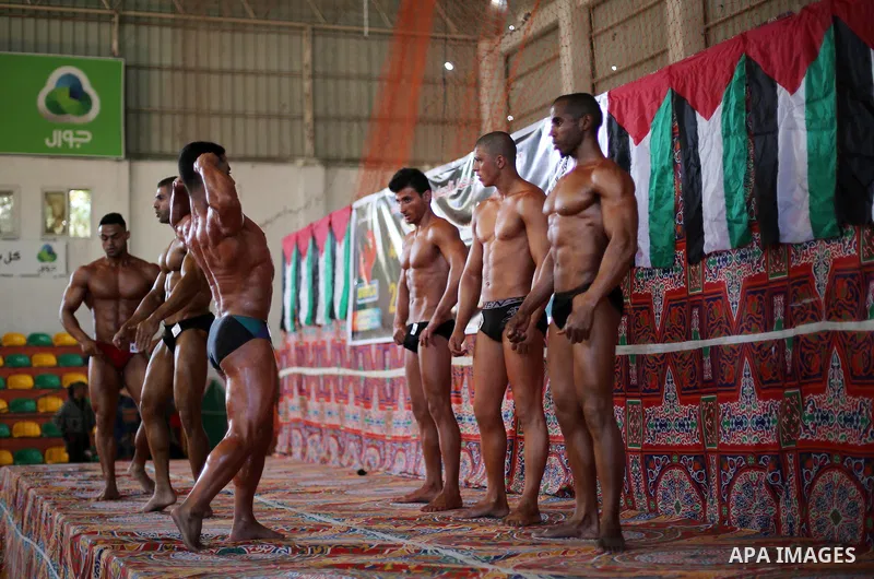 Palestinian men compete in a local bodybuilding competition in Gaza city on October 28, 2016. Photo by Mohammed Asad