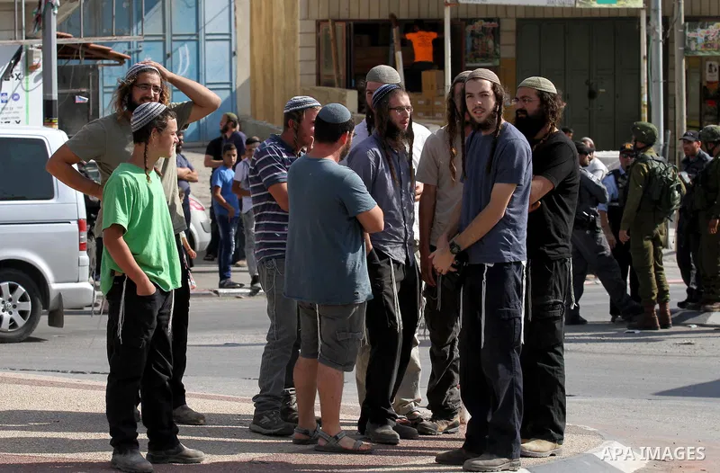 Israeli settlers take part in a protest against Palestinian stones throwers on October 28, 2016 on the main road of the village of Hawara in the northern West Bank. Photo by Nedal Eshtayah