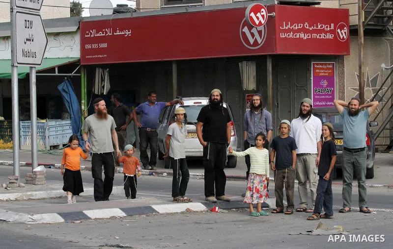 Israeli settlers take part in a protest against Palestinian stones throwers on October 28, 2016 on the main road of the village of Hawara in the northern West Bank. Photo by Nedal Eshtayah
