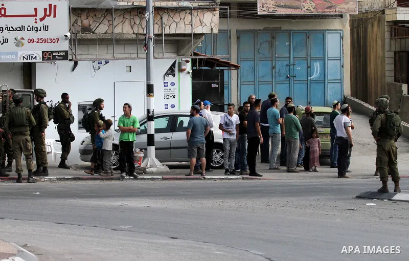 Israeli settlers take part in a protest against Palestinian stones throwers on October 28, 2016 on the main road of the village of Hawara in the northern West Bank. Photo by Nedal Eshtayah