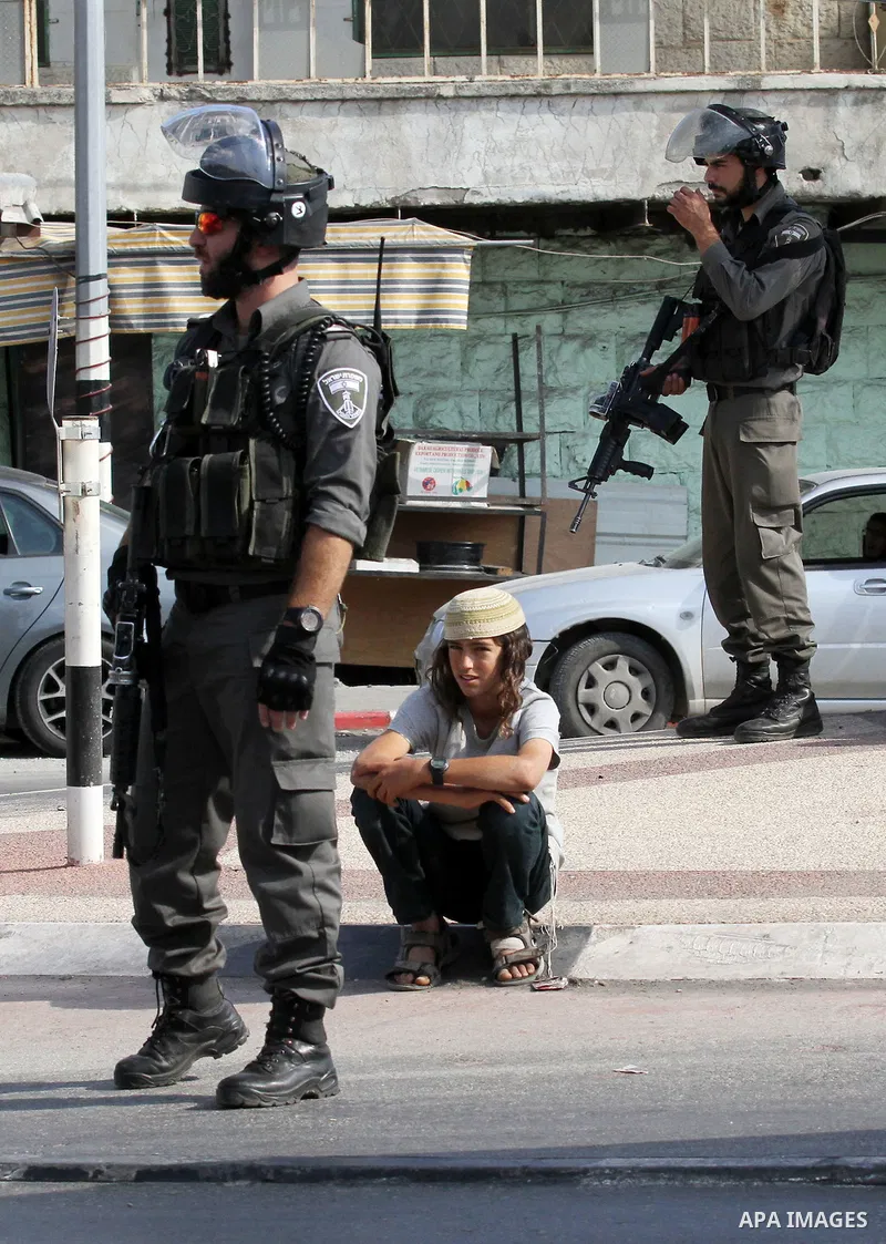 Israeli security forces stand guard as settlers demonstrate against Palestinian stones throwers on October 28, 2016 on the main road of the village of Hawara in the northern West Bank. Photo by Nedal Eshtayah