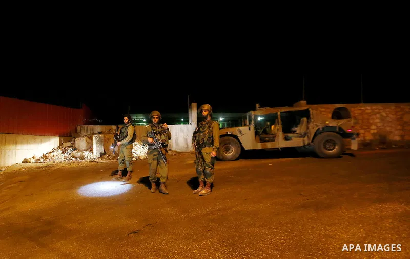 Israeli security forces stand guard near the scene where a Palestinian man was shot dead by Israeli troops at the in the West bank village of Beit Ommar, north of Hebron on October 30, 2016. The Palestinian driver Khaled...