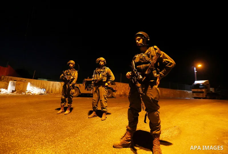 Israeli security forces stand guard near the scene where a Palestinian man was shot dead by Israeli troops at the in the West bank village of Beit Ommar, north of Hebron on October 30, 2016. The Palestinian driver Khaled...