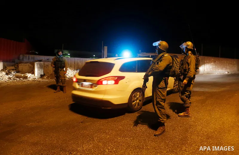Israeli security forces stand guard near the scene where a Palestinian man was shot dead by Israeli troops at the in the West bank village of Beit Ommar, north of Hebron on October 30, 2016. The Palestinian driver Khaled...