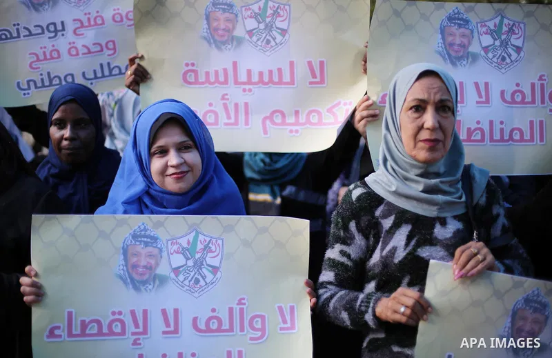 Palestinian women hold posters of late Palestinian leader Yasser Arafat during a rally, in front of Red cross office in Gaza city on October 31, 2016. Photo by Mohammed Asad
