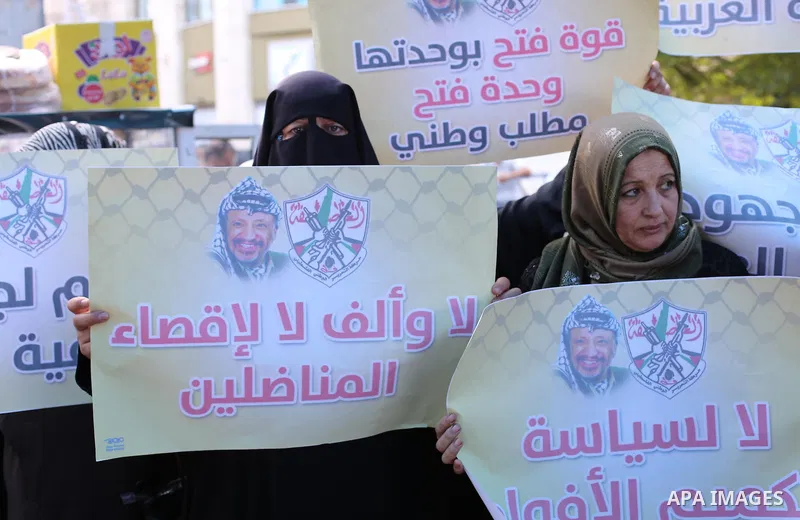 Palestinian women hold posters of late Palestinian leader Yasser Arafat during a rally, in front of Red cross office in Gaza city on October 31, 2016. Photo by Mohammed Asad