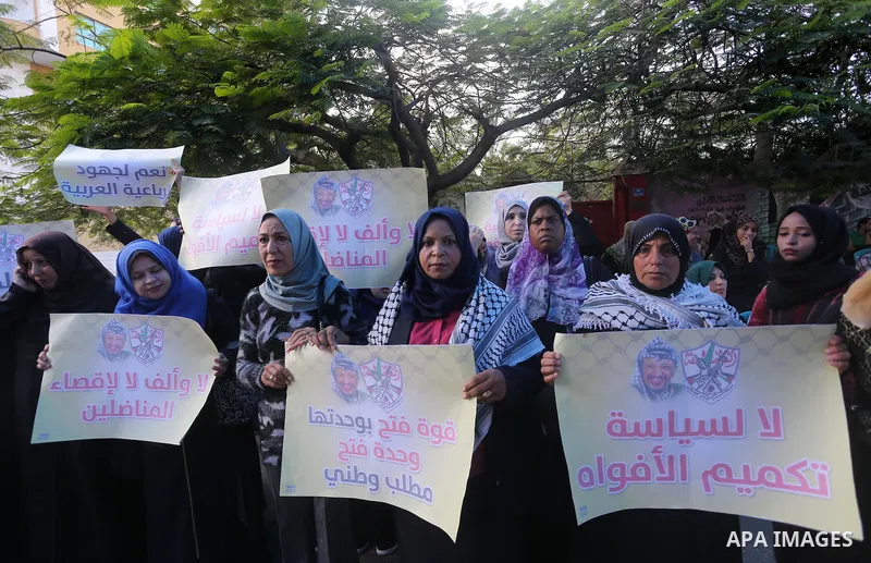 Palestinian women hold posters of late Palestinian leader Yasser Arafat during a rally, in front of Red cross office in Gaza city on October 31, 2016. Photo by Mohammed Asad