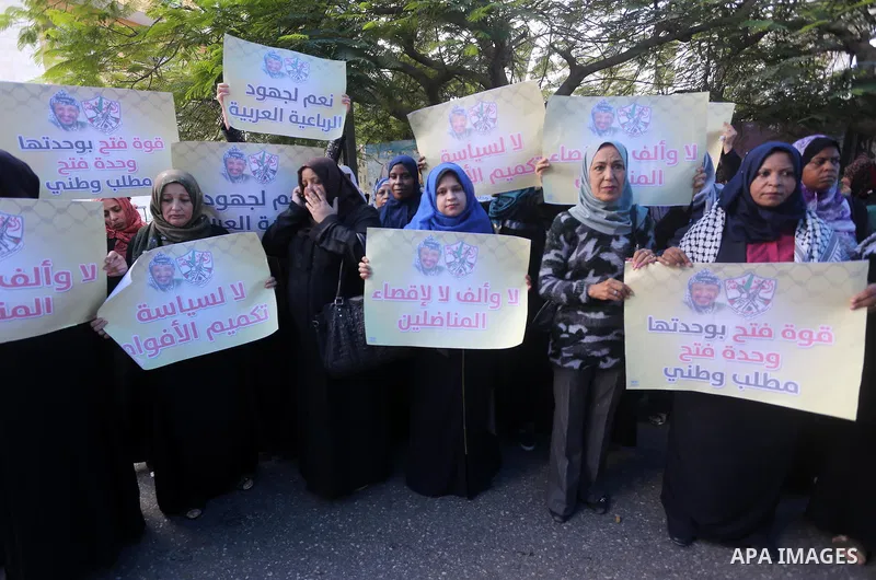 Palestinian women hold posters of late Palestinian leader Yasser Arafat during a rally, in front of Red cross office in Gaza city on October 31, 2016. Photo by Mohammed Asad