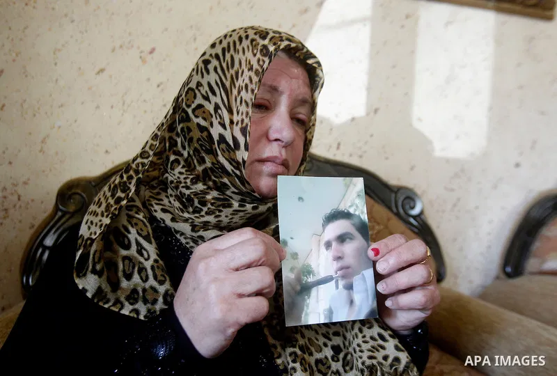 The mother of Palestinian Khaled Ekhlail holds the picture of her son in her house in the West Bank village of Beit Ummar, north of Hebron on October 31, 2016. Israeli army killing of Ekhlail on Sunday evening near Hebro...