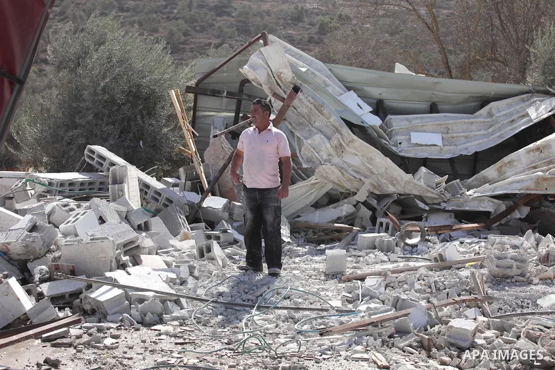 Palestinians inspect the rubble of barracks that was demolished after Israeli authorities said it was built without a permit in the village of Beita, south in the West Bank city of Nablus, on November 3, 2016. Photo by N...