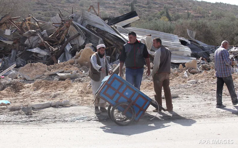 Palestinians inspect the rubble of barracks that was demolished after Israeli authorities said it was built without a permit in the village of Beita, south in the West Bank city of Nablus, on November 3, 2016. Photo by N...