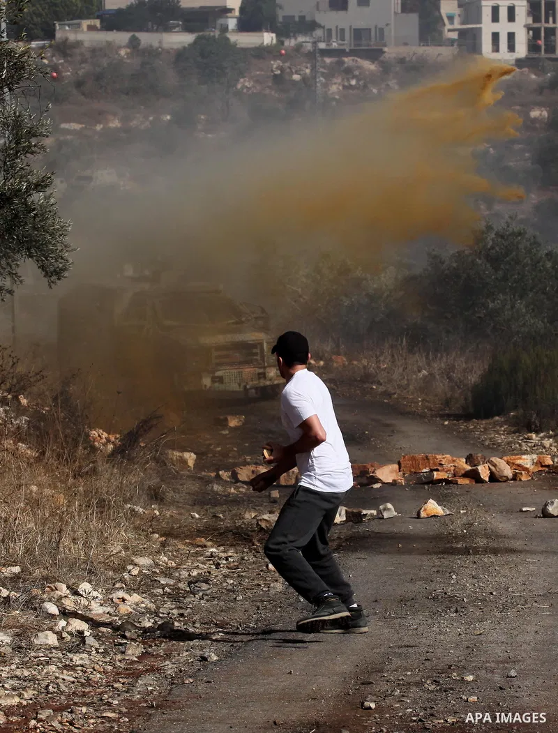 A Palestinian protester hurls stones towards Israeli security forces during clashes following a weekly demonstration against the expropriation of Palestinian land by Israel on Nov. 04, 2016, in the village of Kfar Qaddum...