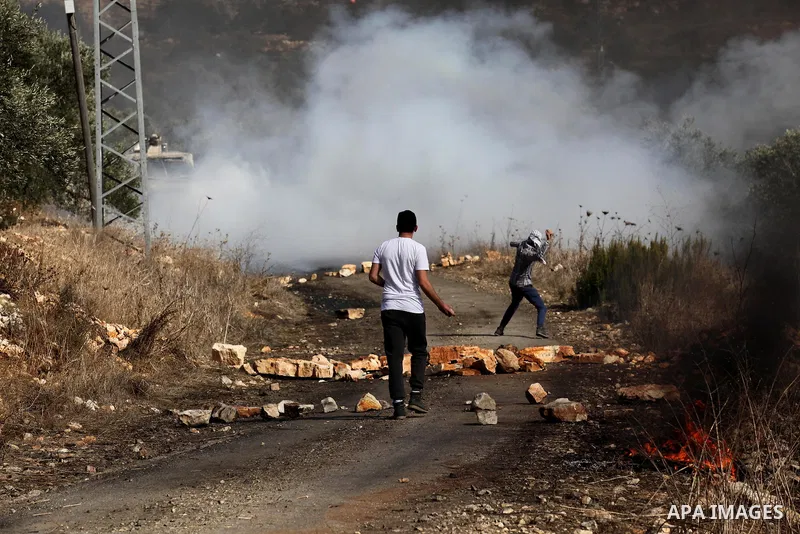 A Palestinian protester hurls stones towards Israeli security forces during clashes following a weekly demonstration against the expropriation of Palestinian land by Israel on Nov. 04, 2016, in the village of Kfar Qaddum...