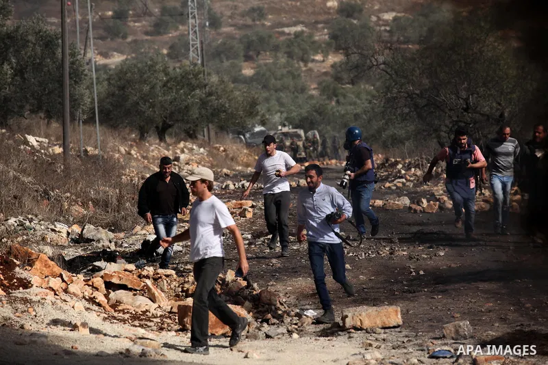 Palestinian protesters run for cover during clashes with Israeli security forces following a weekly demonstration against the expropriation of Palestinian land by Israel on Nov. 04, 2016, in the village of Kfar Qaddum, n...