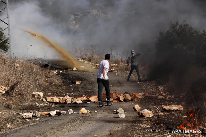 A Palestinian protester hurls stones towards Israeli security forces during clashes following a weekly demonstration against the expropriation of Palestinian land by Israel on Nov. 04, 2016, in the village of Kfar Qaddum...