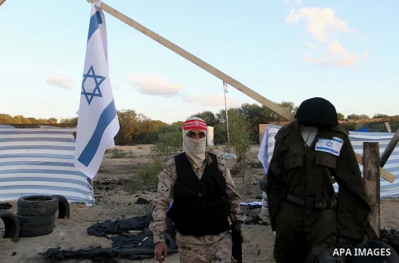 Palestinian militants of the National Resistance brigades, the armed wing of the Democratic Front for the Liberation of Palestine (DFLP), pretend to fight with mock Israeli forces during a graduation ceremony in Rafah, i...