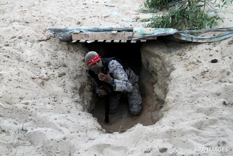 A Palestinian militant of the National Resistance brigades, the armed wing of the Democratic Front for the Liberation of Palestine (DFLP), gets out of a tunnel during a graduation ceremony in Rafah, in the southern Gaza...