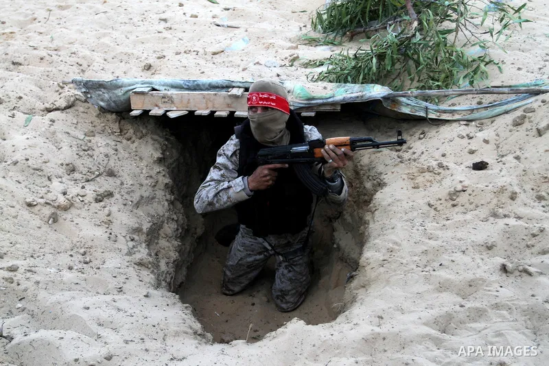 A Palestinian militant of the National Resistance brigades, the armed wing of the Democratic Front for the Liberation of Palestine (DFLP), gets out of a tunnel during a graduation ceremony in Rafah, in the southern Gaza...