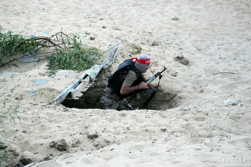 A Palestinian militant of the National Resistance brigades, the armed wing of the Democratic Front for the Liberation of Palestine (DFLP), gets out of a tunnel during a graduation ceremony in Rafah, in the southern Gaza...
