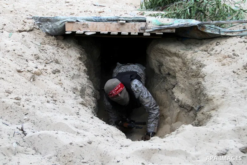 A Palestinian militant of the National Resistance brigades, the armed wing of the Democratic Front for the Liberation of Palestine (DFLP), gets out of a tunnel during a graduation ceremony in Rafah, in the southern Gaza...