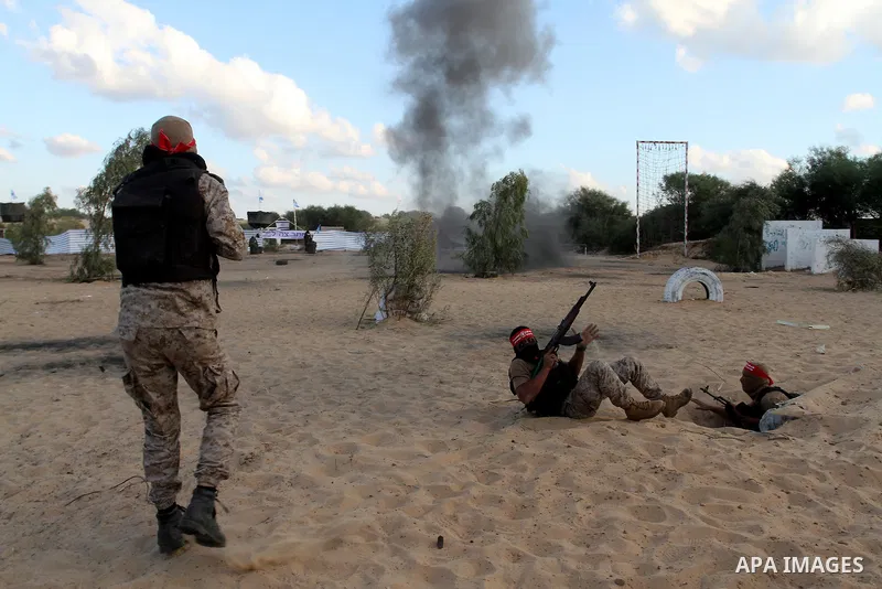 Palestinian militants of the National Resistance brigades, the armed wing of the Democratic Front for the Liberation of Palestine (DFLP), pretend to fight with mock Israeli forces during a graduation ceremony in Rafah, i...