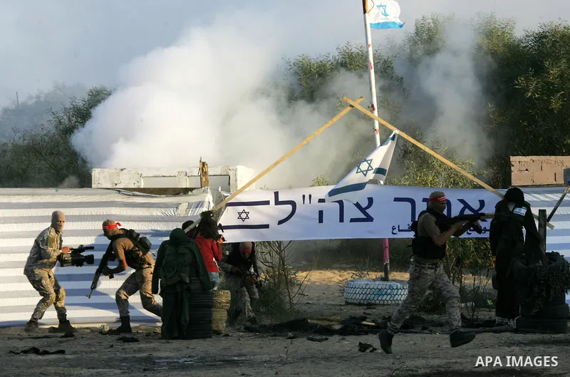 Palestinian militants of the National Resistance brigades, the armed wing of the Democratic Front for the Liberation of Palestine (DFLP), pretend to fight with mock Israeli forces during a graduation ceremony in Rafah, i...
