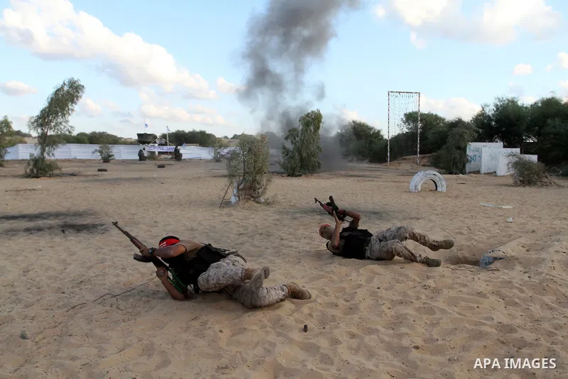 Palestinian militants of the National Resistance brigades, the armed wing of the Democratic Front for the Liberation of Palestine (DFLP), pretend to fight with mock Israeli forces during a graduation ceremony in Rafah, i...