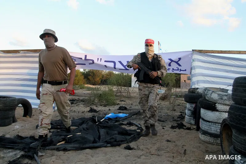 Palestinian militants of the National Resistance brigades, the armed wing of the Democratic Front for the Liberation of Palestine (DFLP), pretend to fight with mock Israeli forces during a graduation ceremony in Rafah, i...