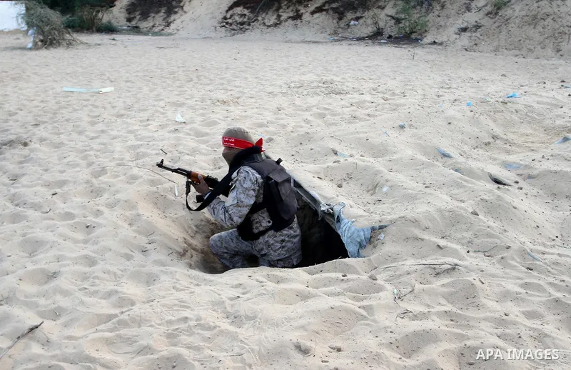 A Palestinian militant of the National Resistance brigades, the armed wing of the Democratic Front for the Liberation of Palestine (DFLP), gets out of a tunnel during a graduation ceremony in Rafah, in the southern Gaza...