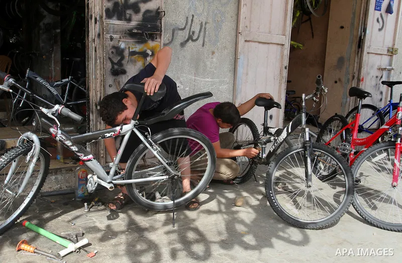 A Palestinian boy works at a mechanic shop in Rafah in the southern Gaza strip, on November 7, 2016. Photo by Abed Rahim Khatib