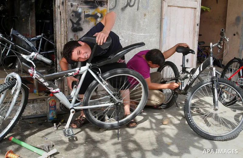 A Palestinian boy works at a mechanic shop in Rafah in the southern Gaza strip, on November 7, 2016. Photo by Abed Rahim Khatib