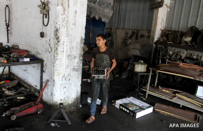 A Palestinian boy works at a mechanic shop in Rafah in the southern Gaza strip, on November 7, 2016. Photo by Abed Rahim Khatib
