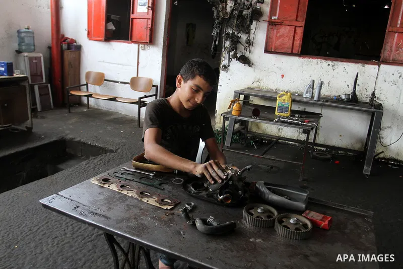 A Palestinian boy works at a mechanic shop in Rafah in the southern Gaza strip, on November 7, 2016. Photo by Abed Rahim Khatib