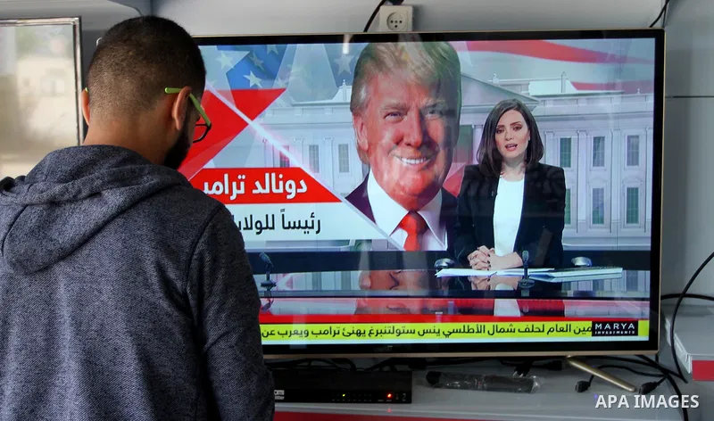 A Palestinian man watches broadcasting of the 2016 U.S. presidential election results on TV in Rahaf in the southern Gaza strip, on November 9, 2016. Republican Donald Trump has been elected the 45th president of the Uni...
