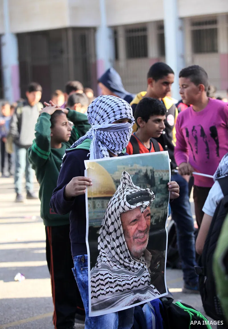 Palestinian school boys hold posters of the late Palestinian leader Yasser Arafat to mark the 12 anniversary of his death in the West Bank village of Salem just east of the city of Nablus on November 10, 2016. Photo by N...