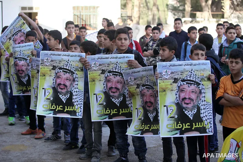 Palestinian school boys hold posters of the late Palestinian leader Yasser Arafat to mark the 12 anniversary of his death in the West Bank village of Salem just east of the city of Nablus on November 10, 2016. Photo by N...