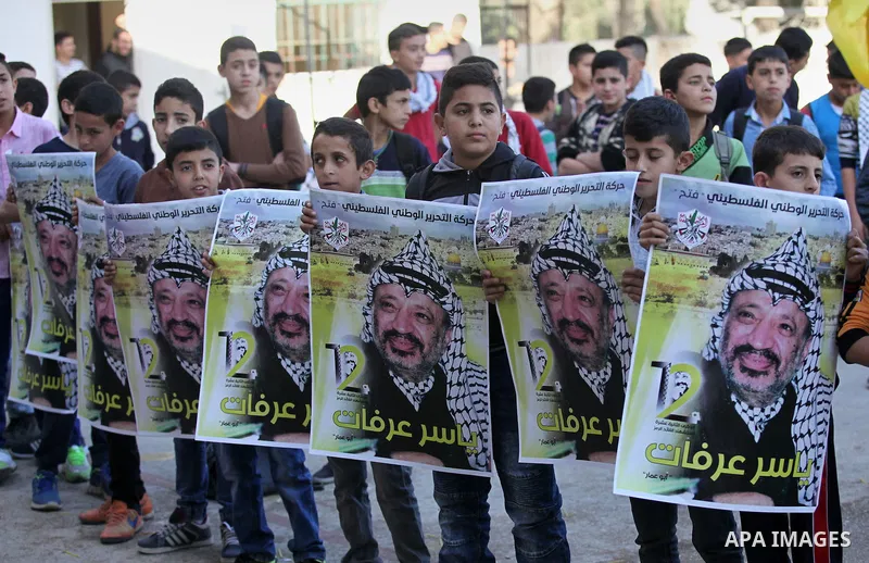 Palestinian school boys hold posters of the late Palestinian leader Yasser Arafat to mark the 12 anniversary of his death in the West Bank village of Salem just east of the city of Nablus on November 10, 2016. Photo by N...
