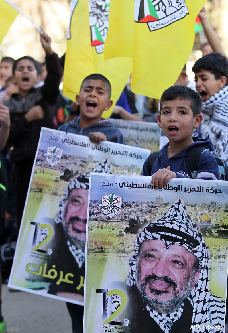 Palestinian school boys hold posters of the late Palestinian leader Yasser Arafat to mark the 12 anniversary of his death in the West Bank village of Salem just east of the city of Nablus on November 10, 2016. Photo by N...