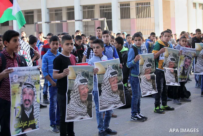 Palestinian school boys hold posters of the late Palestinian leader Yasser Arafat to mark the 12 anniversary of his death in the West Bank village of Salem just east of the city of Nablus on November 10, 2016. Photo by N...
