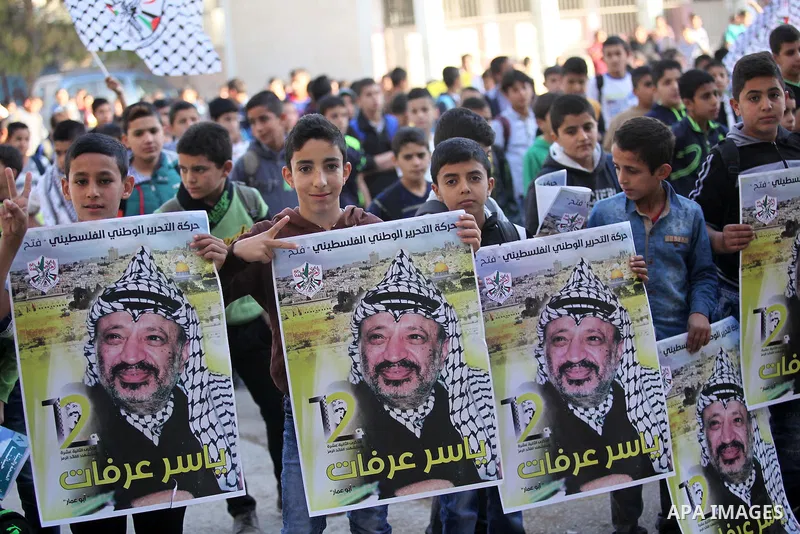 Palestinian school boys hold posters of the late Palestinian leader Yasser Arafat to mark the 12 anniversary of his death in the West Bank village of Salem just east of the city of Nablus on November 10, 2016. Photo by N...