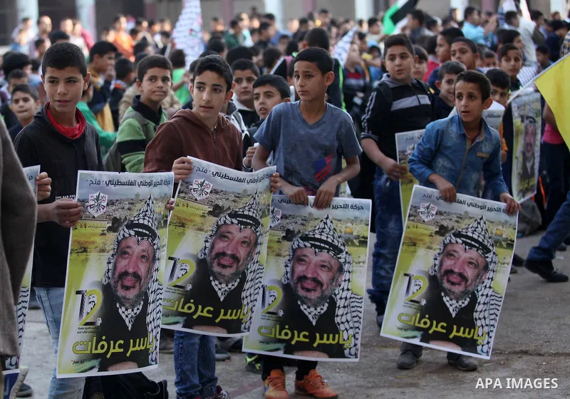 Palestinian school boys hold posters of the late Palestinian leader Yasser Arafat to mark the 12 anniversary of his death in the West Bank village of Salem just east of the city of Nablus on November 10, 2016. Photo by N...