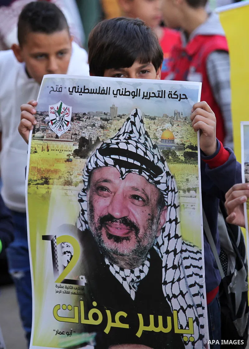 Palestinian school boys hold posters of the late Palestinian leader Yasser Arafat to mark the 12 anniversary of his death in the West Bank village of Salem just east of the city of Nablus on November 10, 2016. Photo by N...